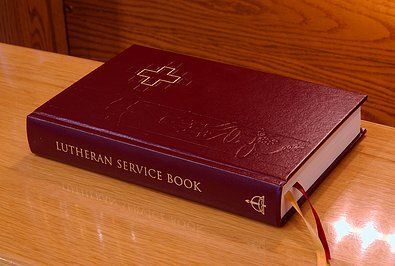 A lutheran service book is sitting on a wooden table