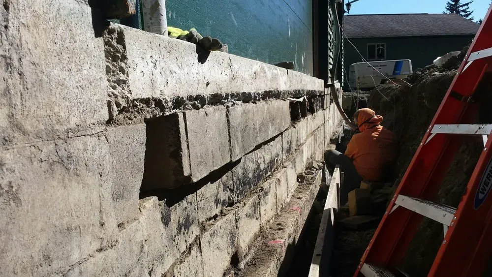 A ladder is sitting next to a brick wall