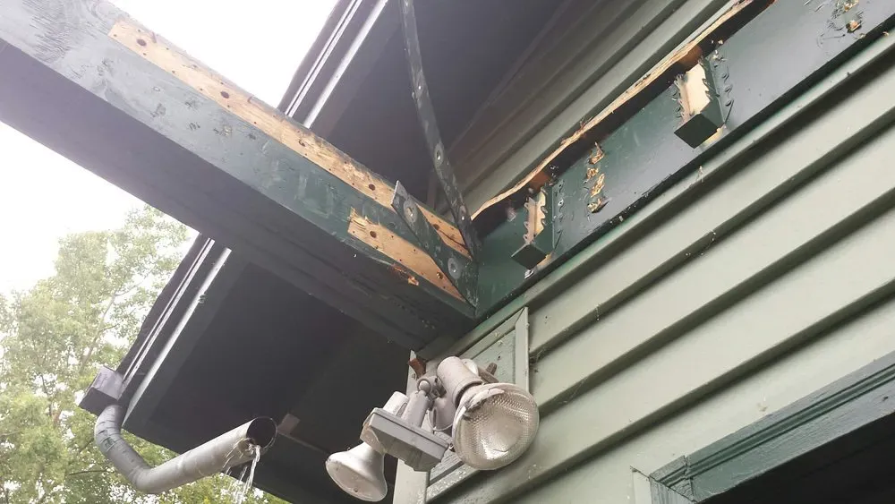 A house with a broken roof and a light on the side of it.