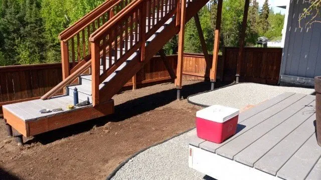 A deck with stairs and a red cooler on it