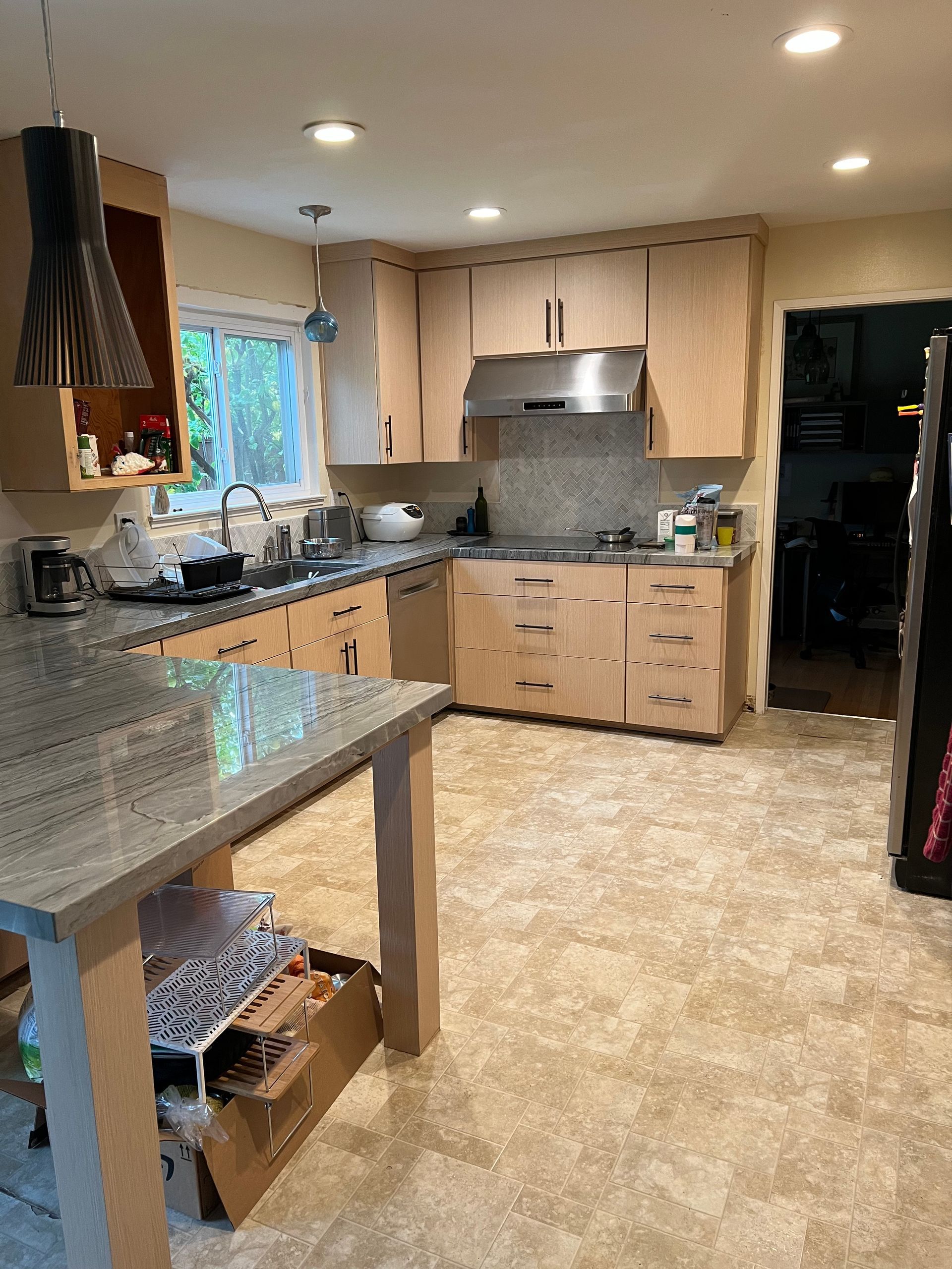 A kitchen with wooden cabinets , granite counter tops , and stainless steel appliances.