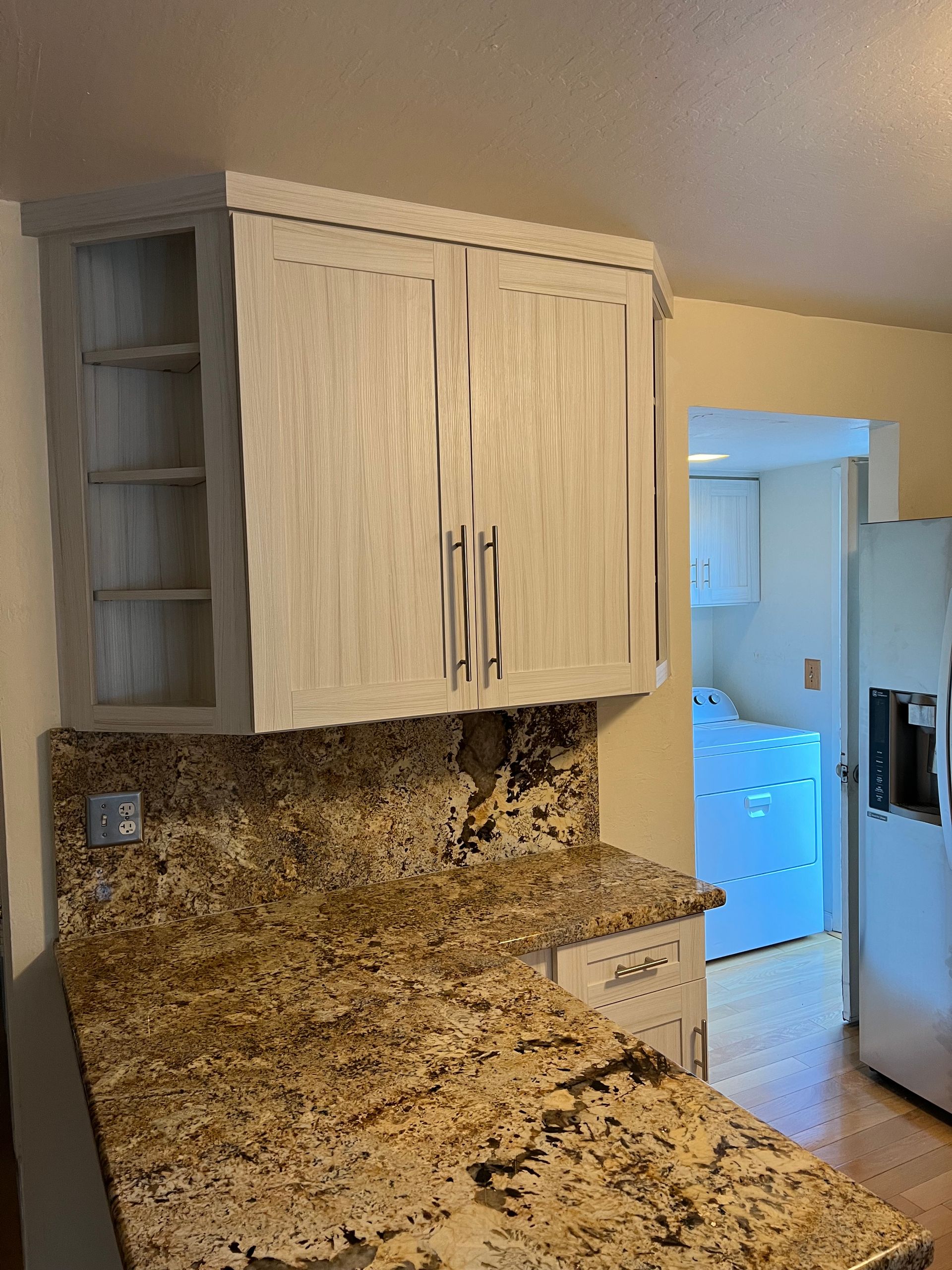 A kitchen with granite counter tops and white cabinets.