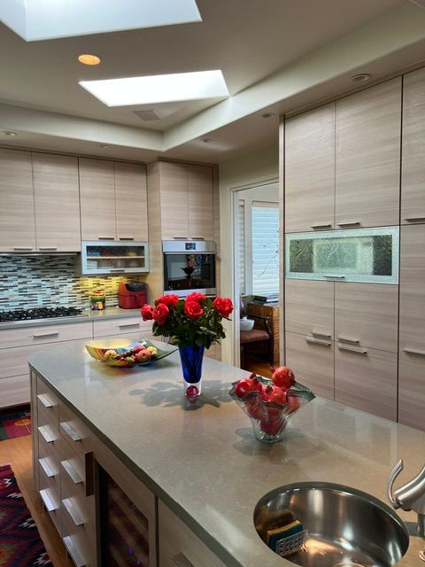 A kitchen with a sink and a vase of flowers on the counter