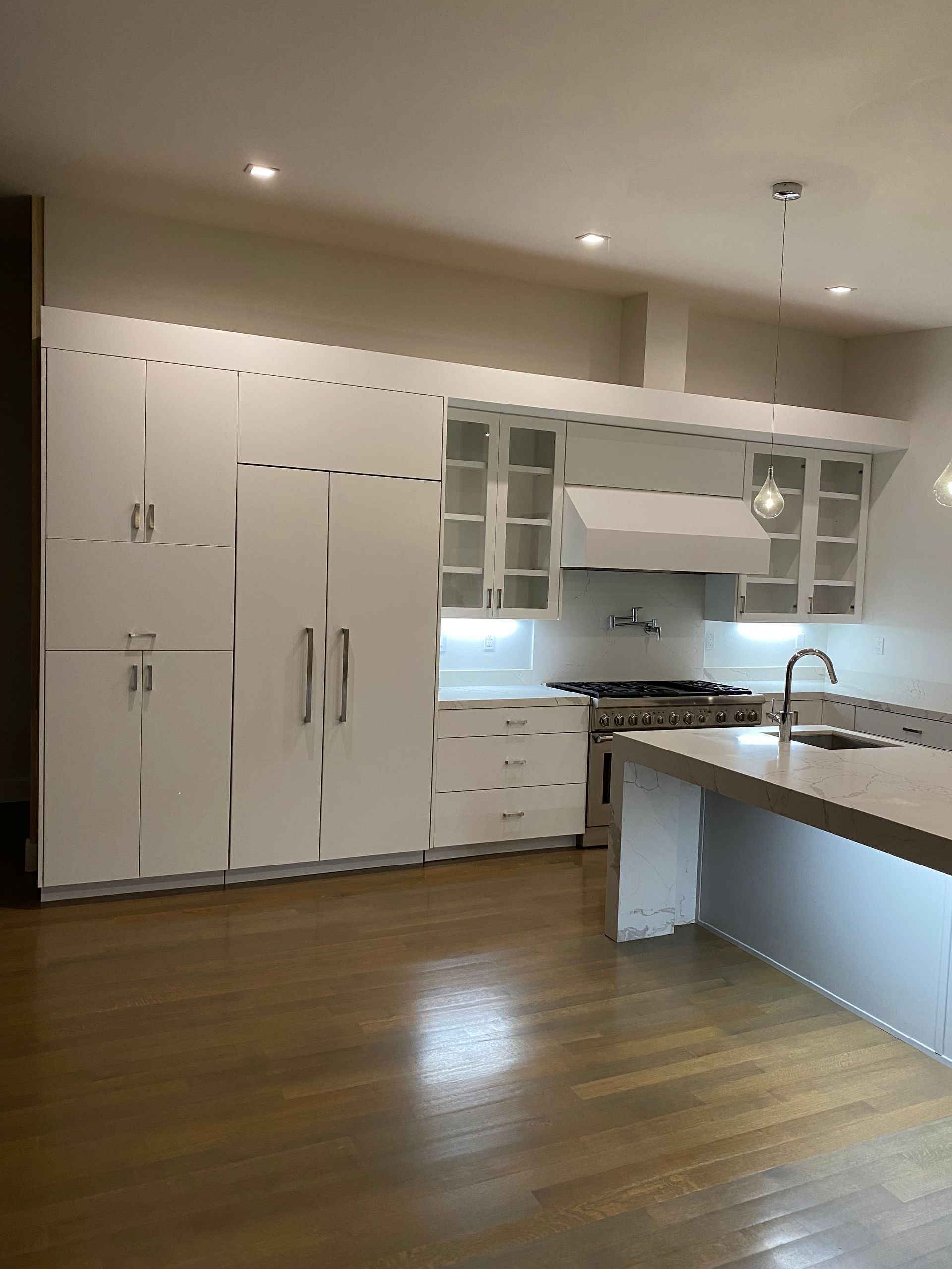A kitchen with white cabinets and a large island