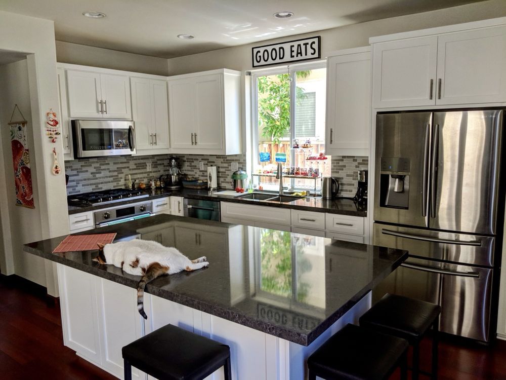 A kitchen with stainless steel appliances and a sign that says `` good eats '' on the wall.