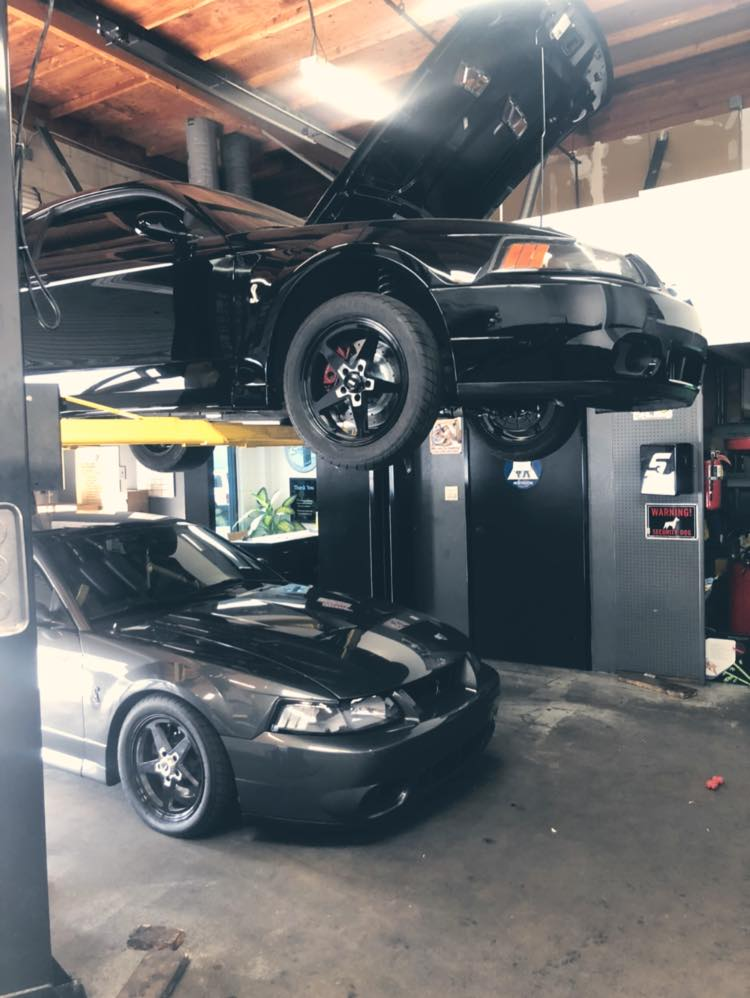 A Black Car on a Lift | Niko's Automotive Repair