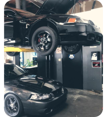 black car on lift | Nikos Automotive