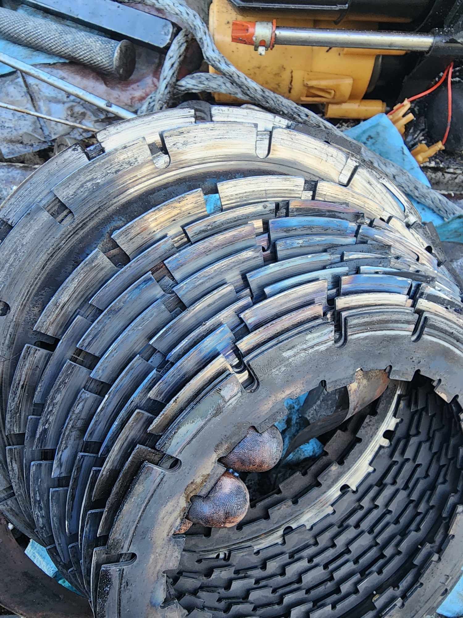 Pile of worn, metal clutch plates. Some have rust and wear.