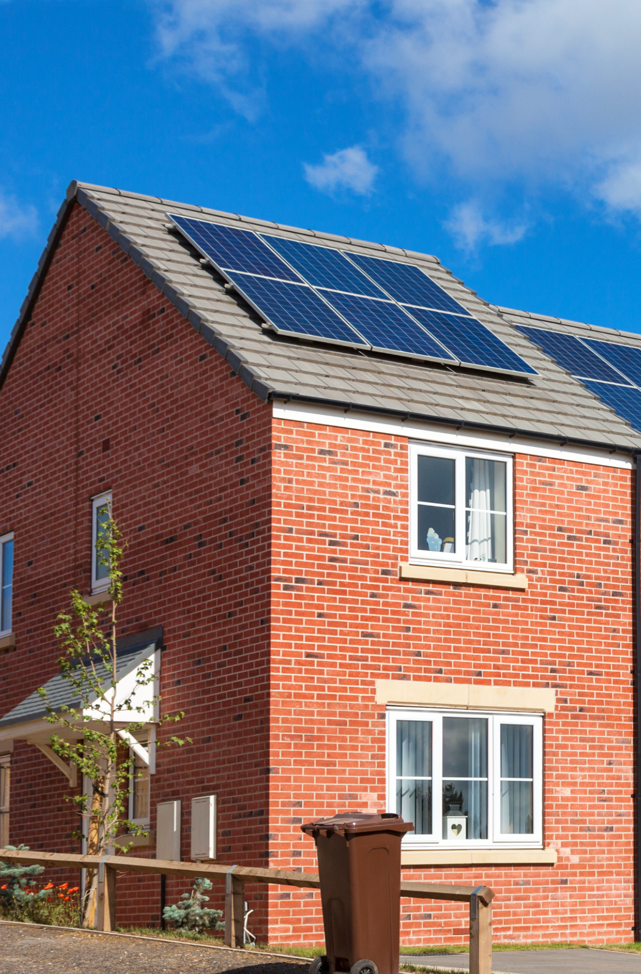 A brick house with solar panels on the roof.
