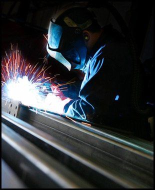a man welding and sparks coming from the steel