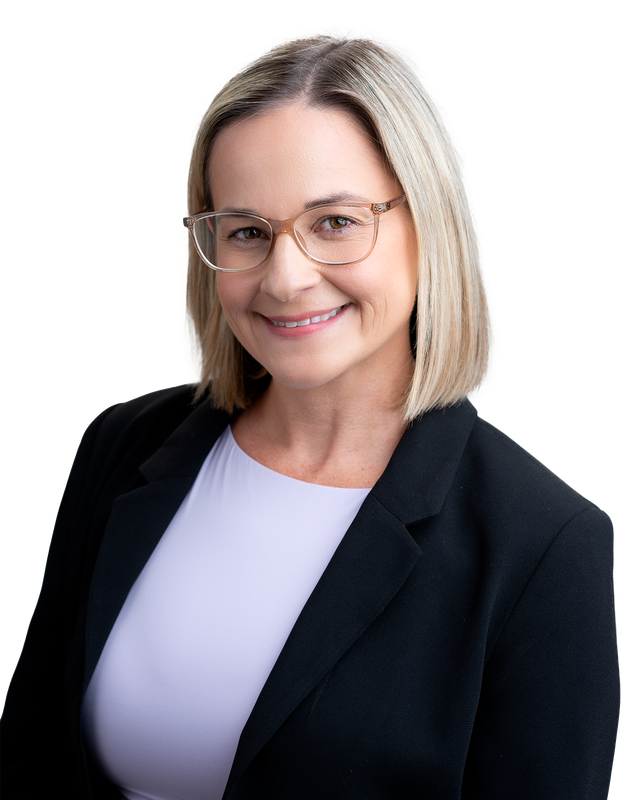 Smiling woman with blonde hair and glasses wearing a black blazer and light lavender top on a white background