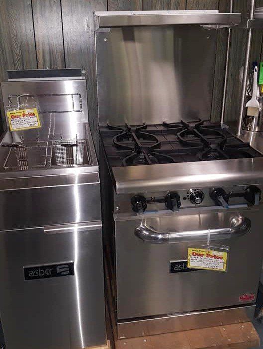 A stainless steel stove and fryer are sitting next to each other in a kitchen.