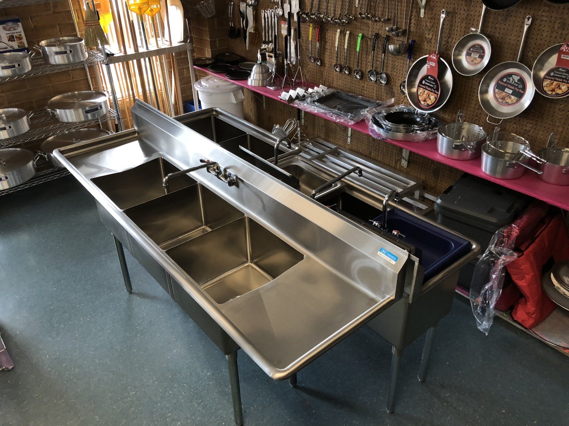 Two stainless steel sinks are sitting on a counter in a kitchen.