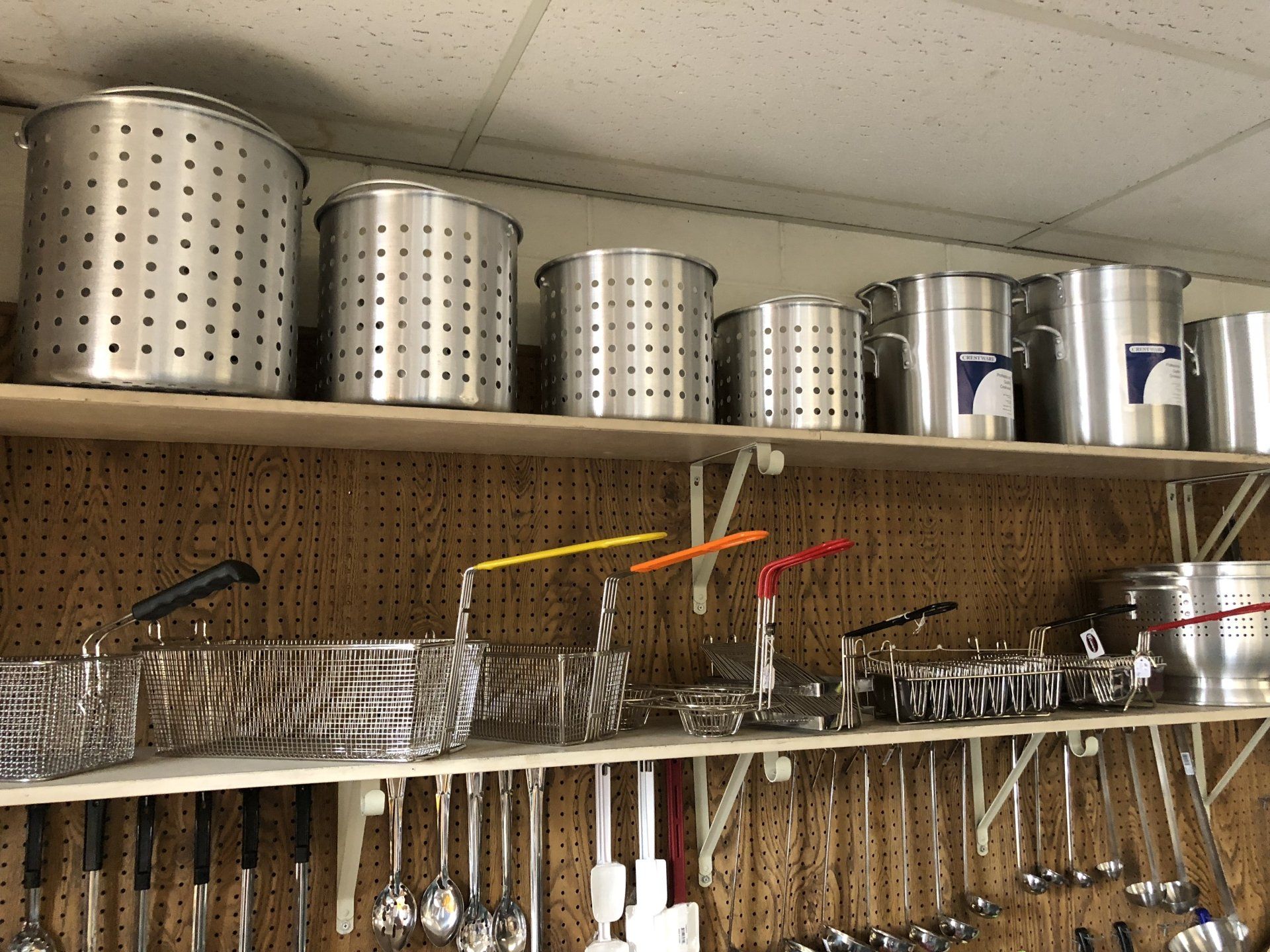 A shelf full of pots and pans and utensils