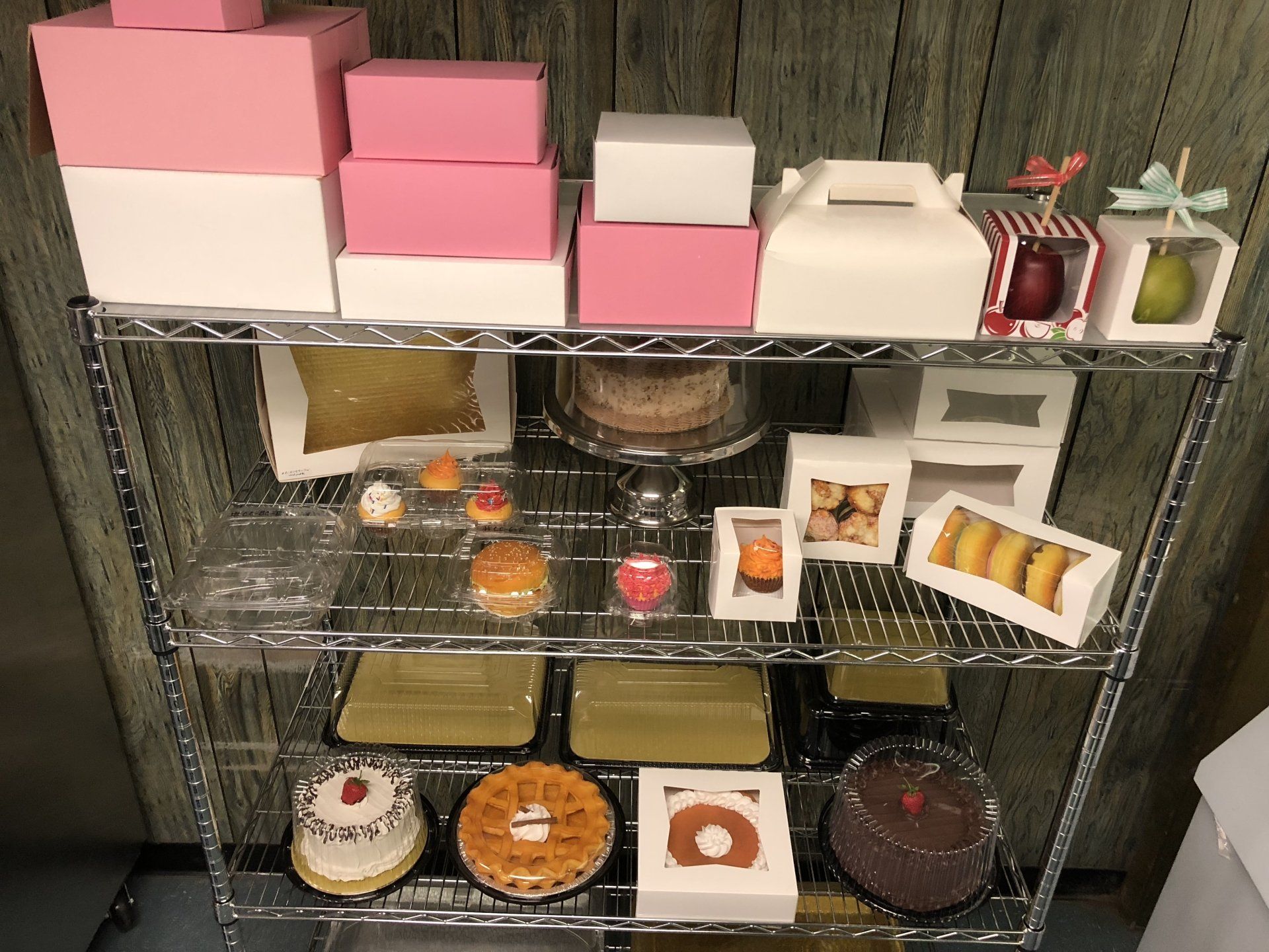 A shelf filled with different types of cakes and boxes
