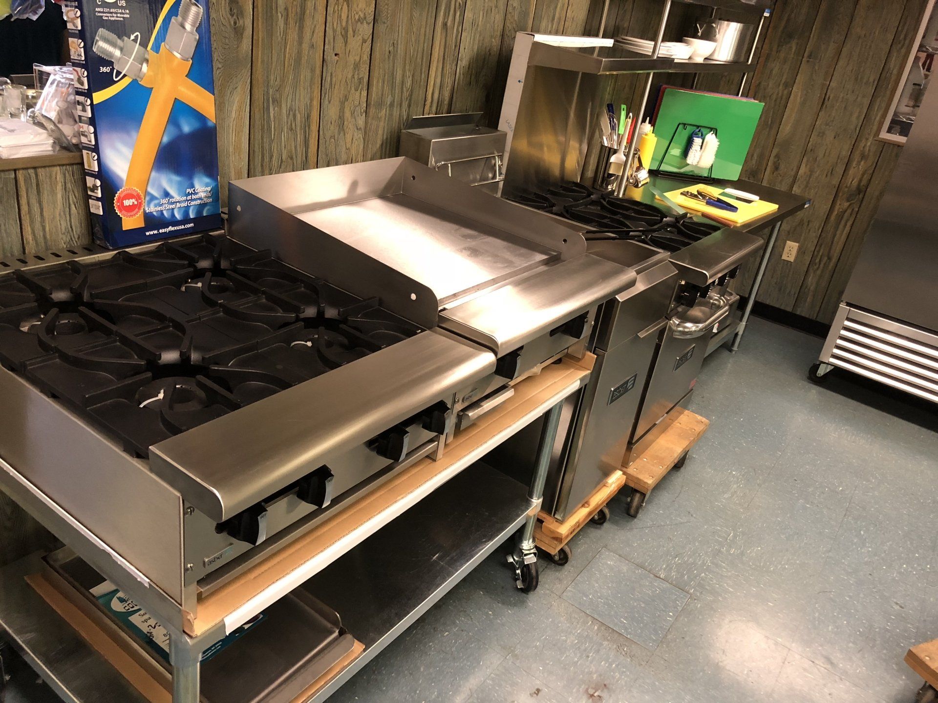 A stainless steel stove is sitting on a cart in a kitchen