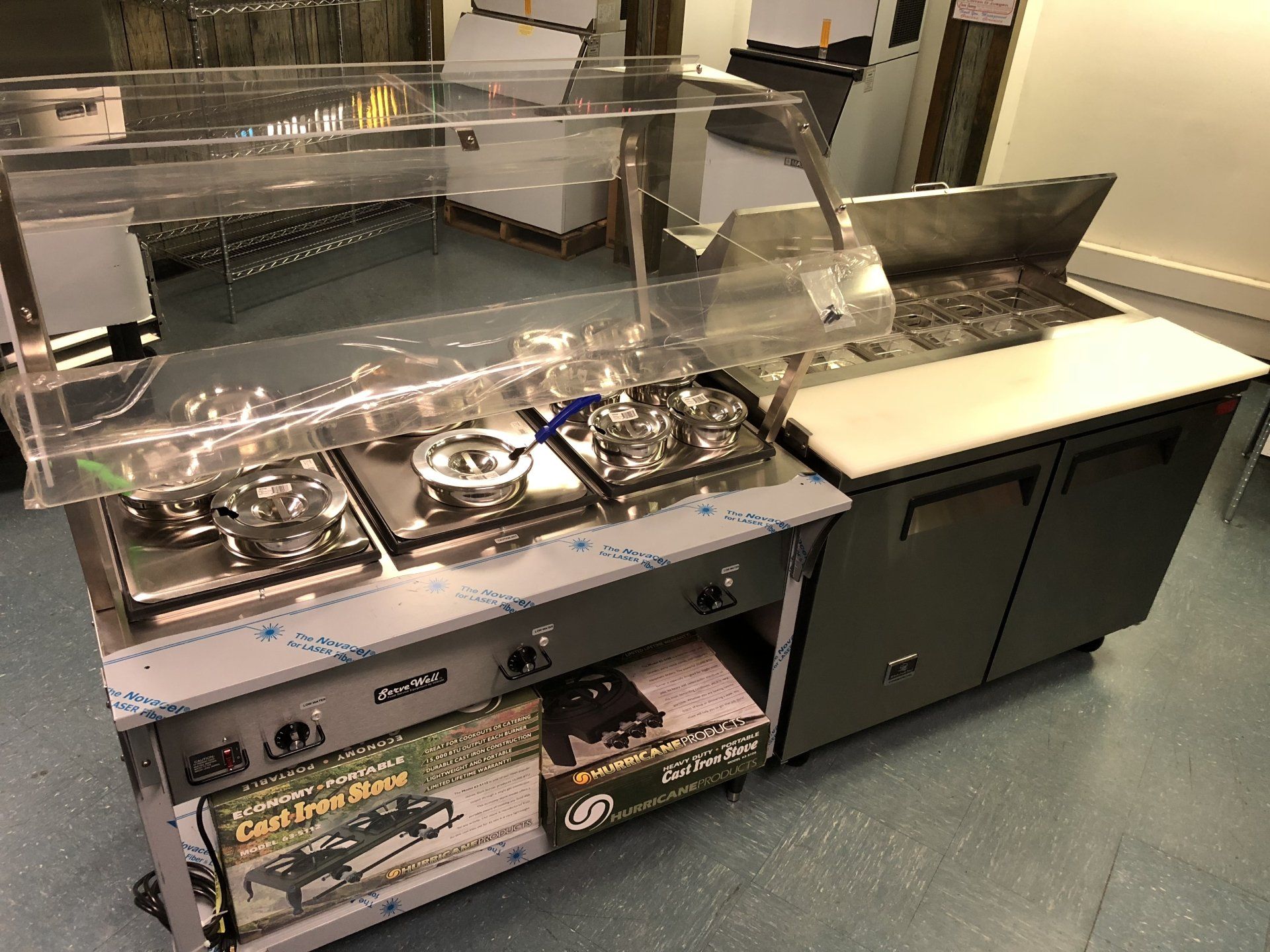 A stainless steel kitchen with a clear display case