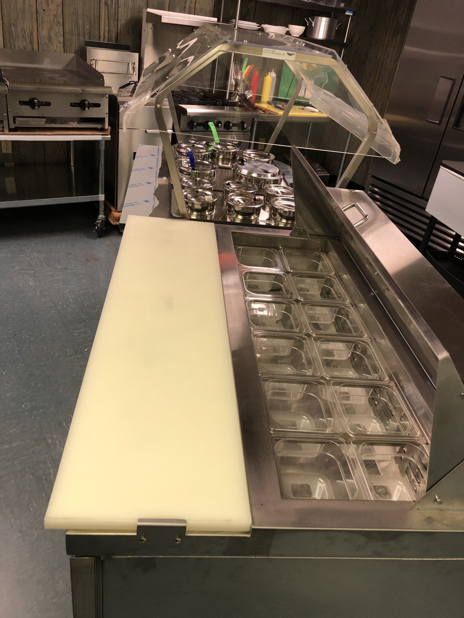 A stainless steel counter with a cutting board on it