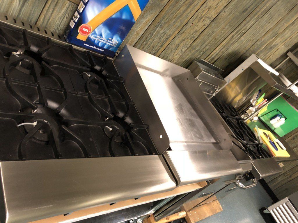 A stainless steel stove top oven is sitting in a kitchen.