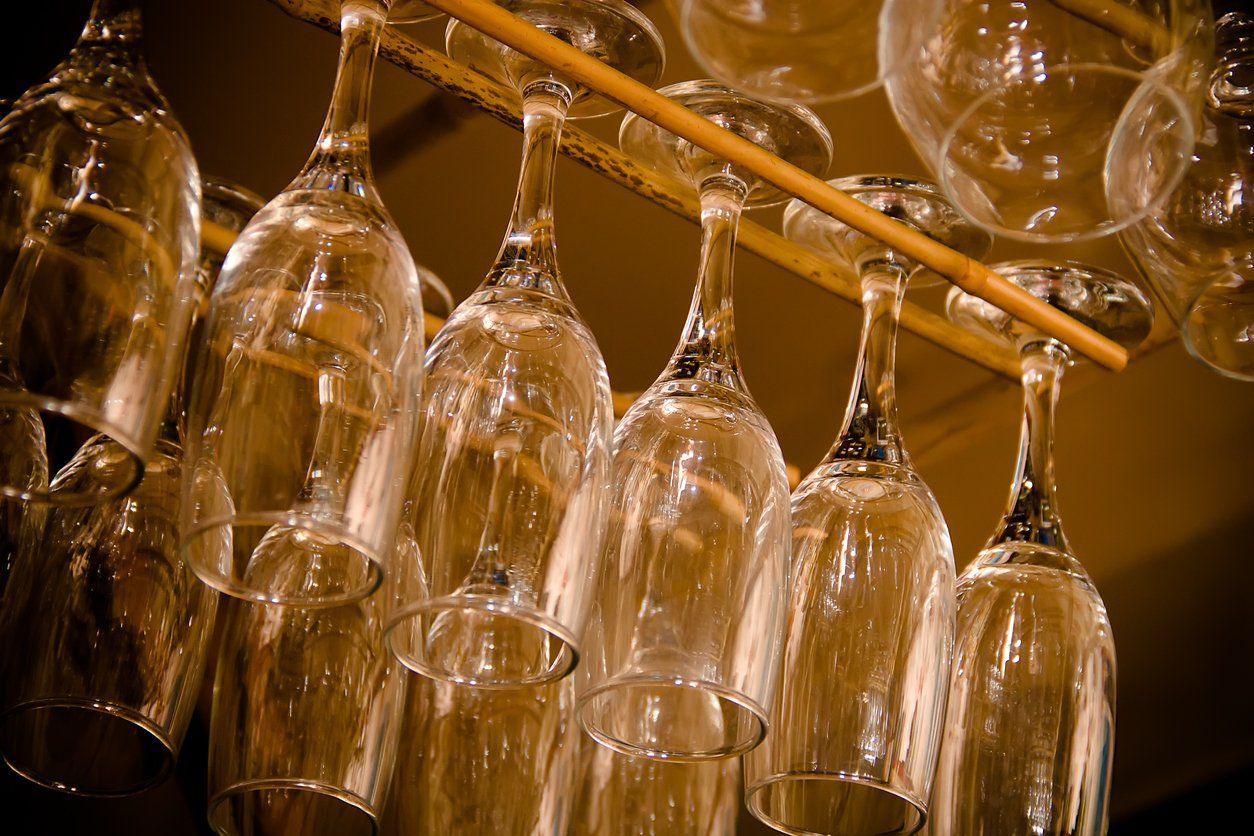 A bunch of wine glasses are hanging from a rack.