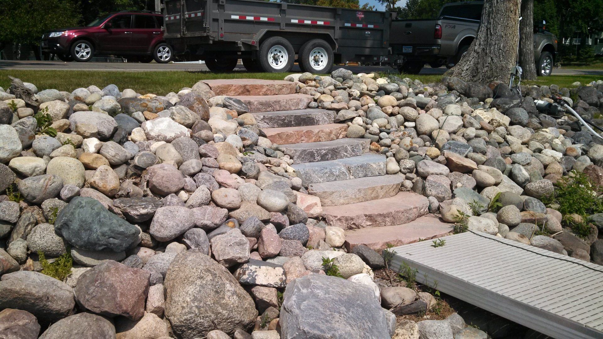 A truck is parked on the side of the road next to a pile of rocks.