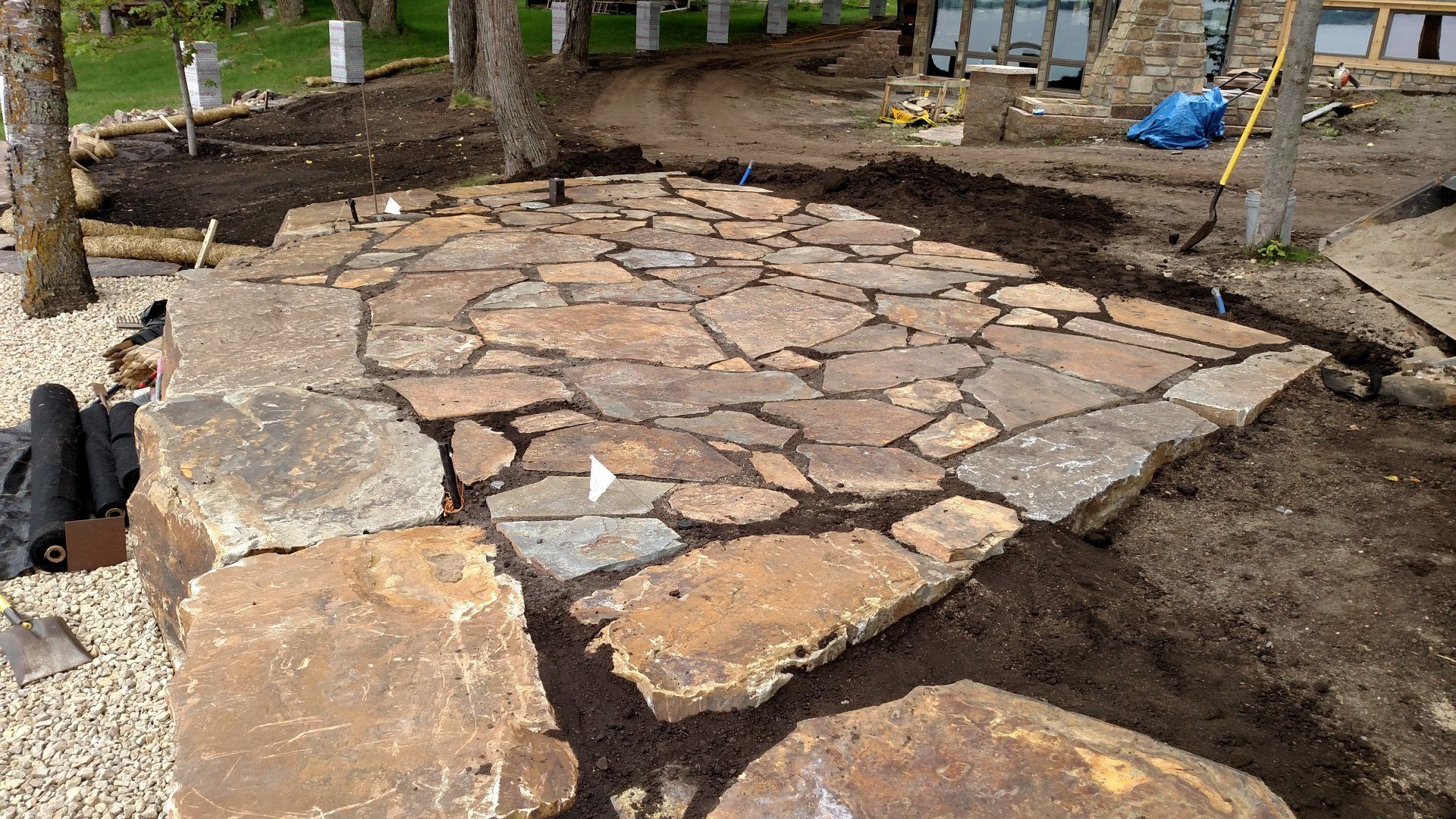 A stone walkway is being built in a backyard.