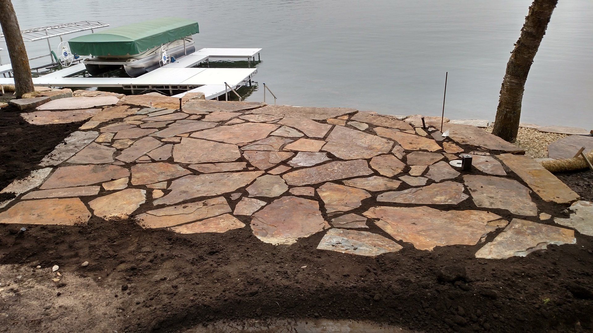 A boat is docked on a dock next to a stone walkway