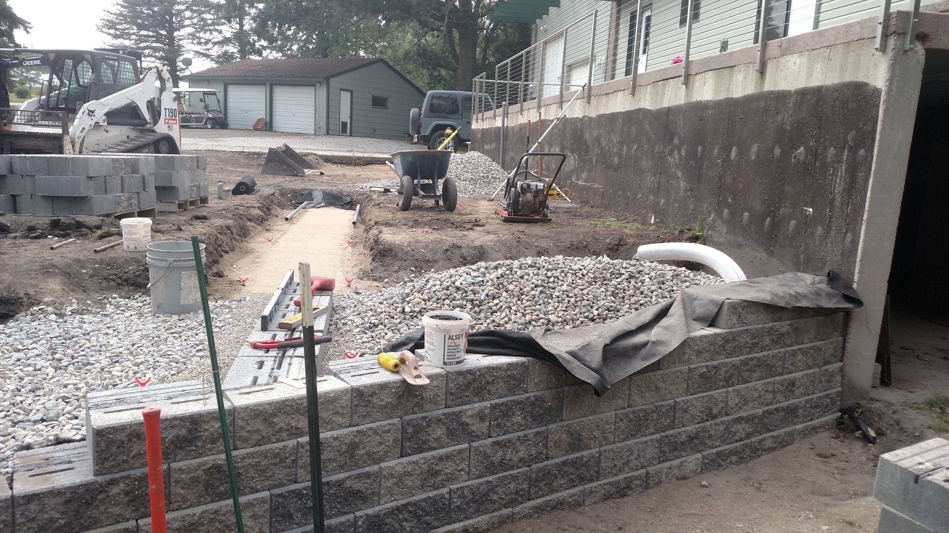 A brick wall is being built in front of a house.
