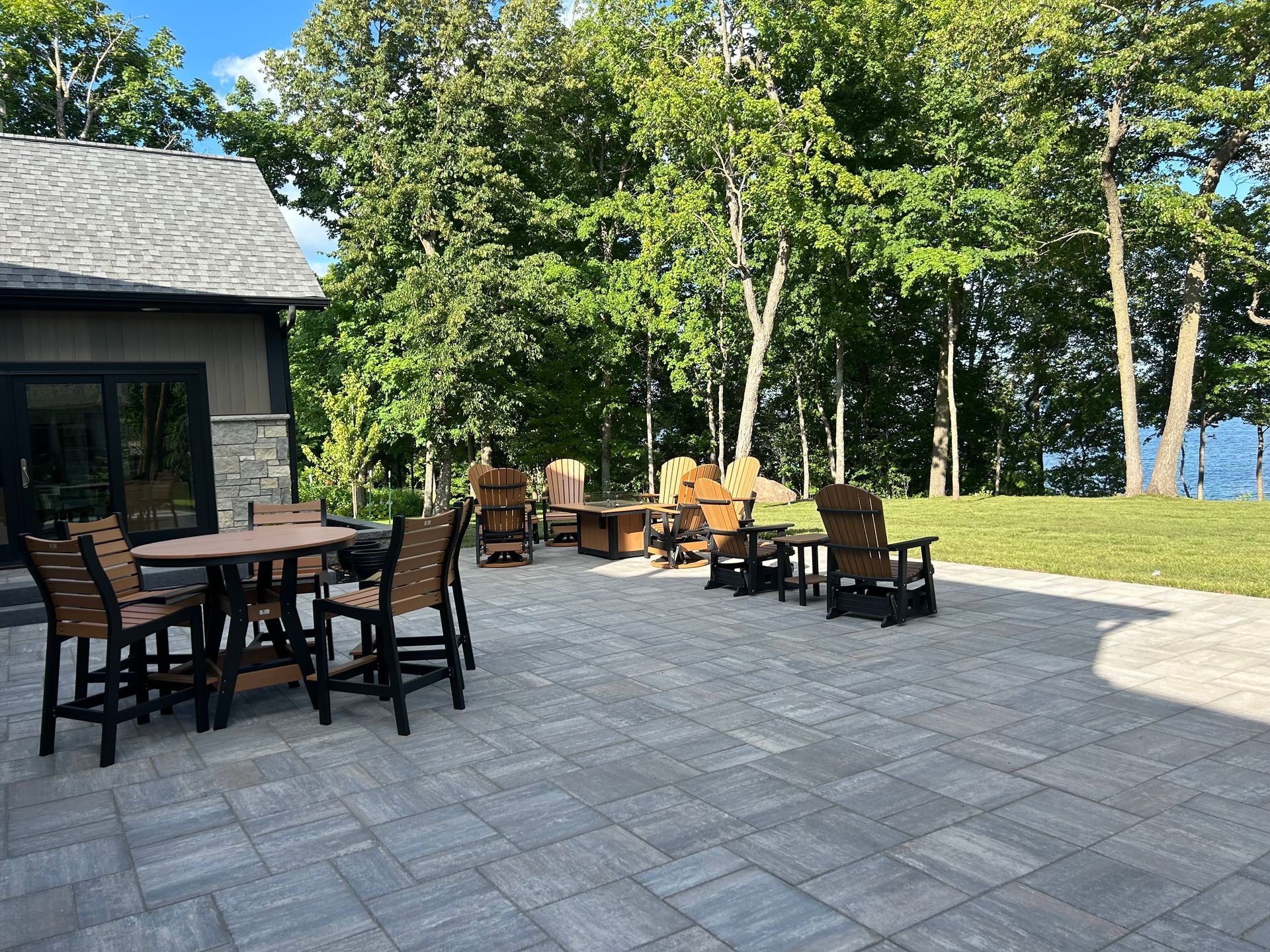 A patio with tables and chairs in front of a house.