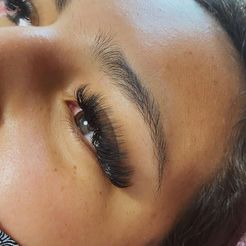 A close up of a woman 's face with long eyelashes.