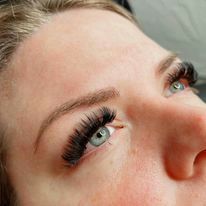 A close up of a woman 's face with long eyelashes.
