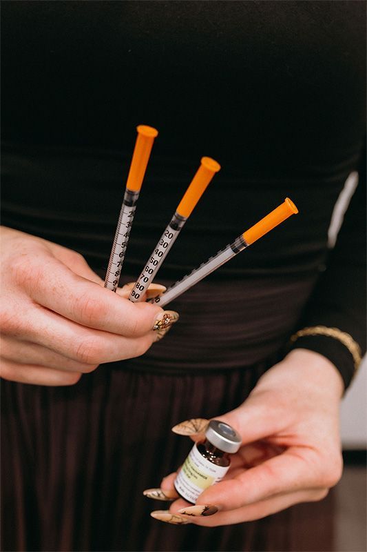 Four women are posing for a picture while sitting on a couch.