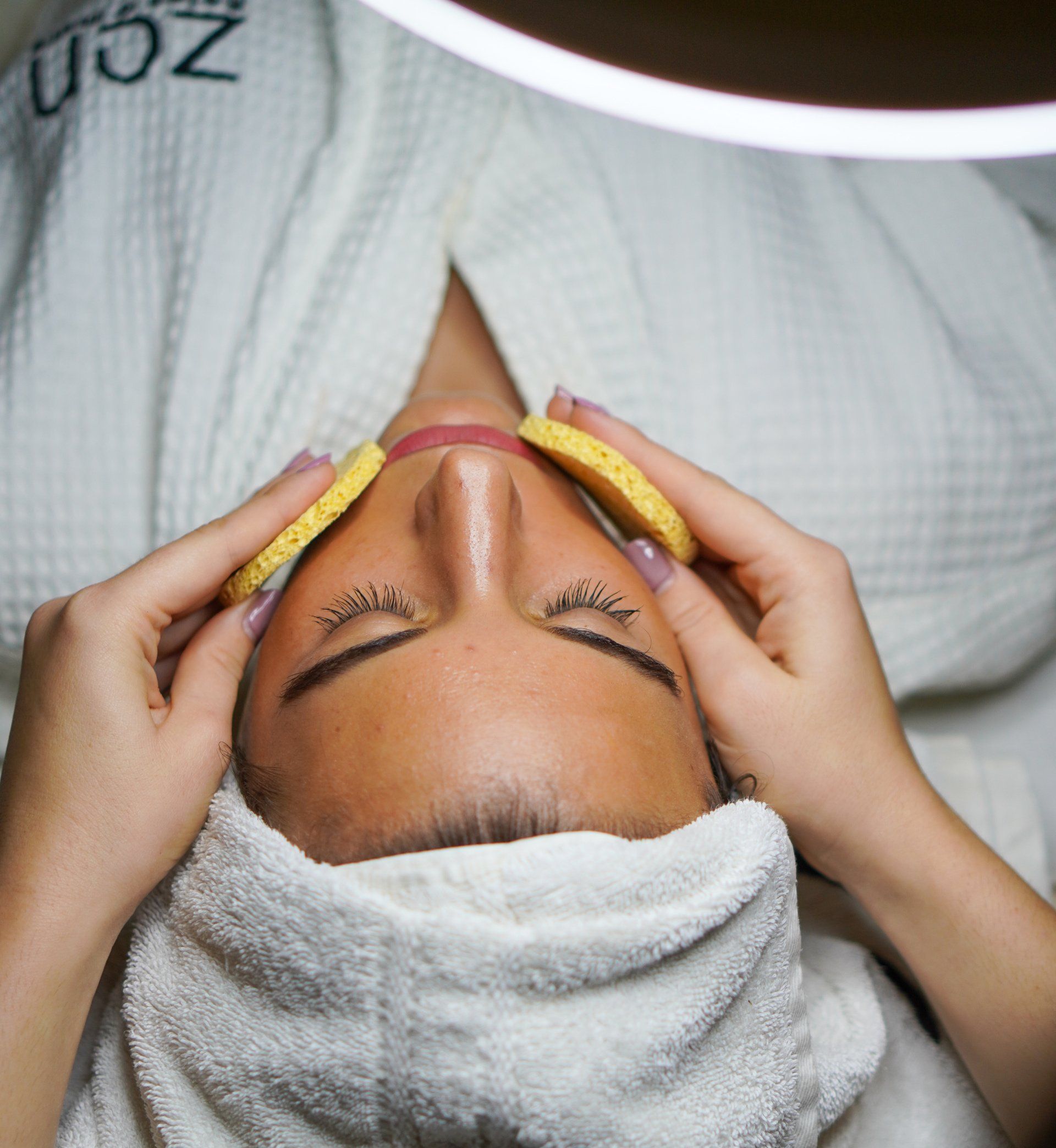 A woman with a towel around her head is getting a massage