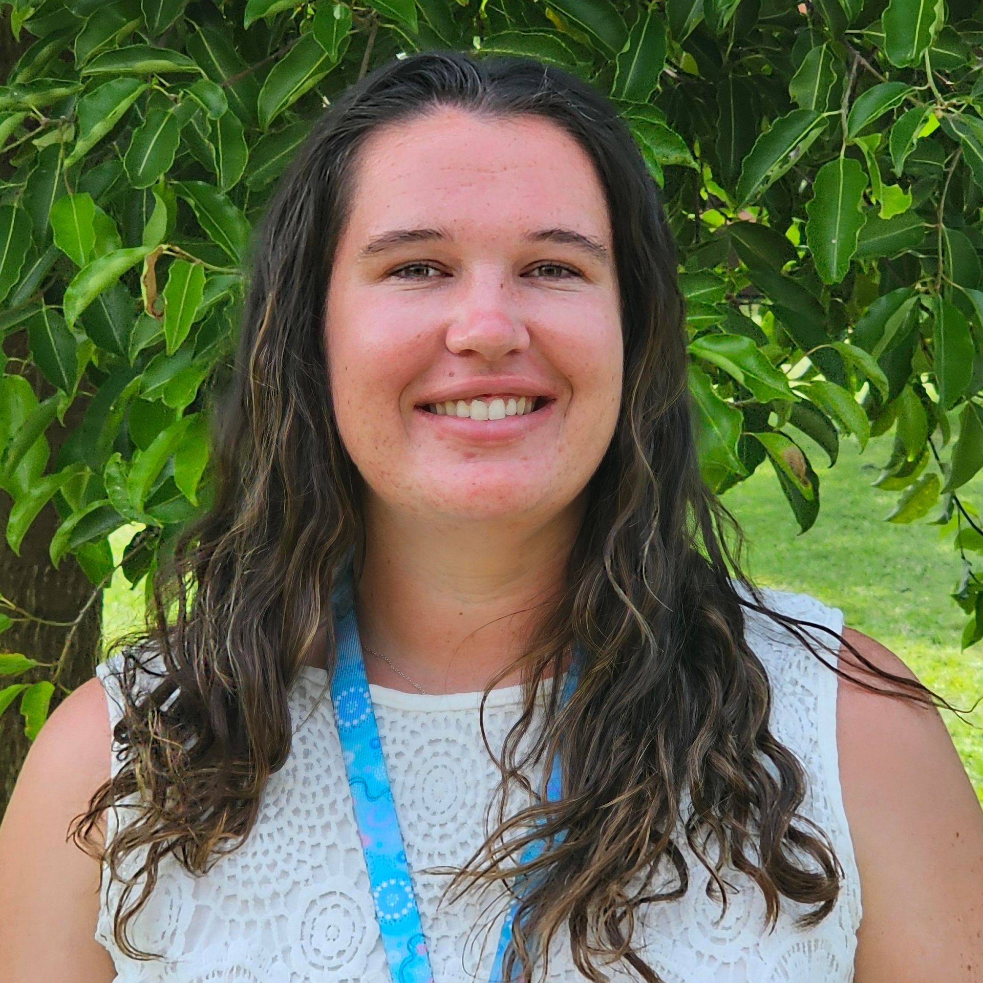 Classroom with tables, red chairs, bookshelves, and colorful decorations.