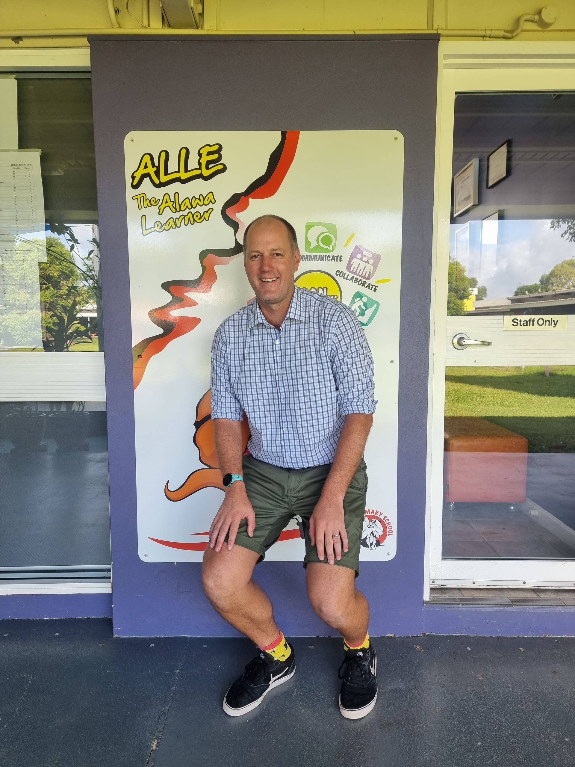 Woman with blonde hair smiles outdoors, wearing a zebra-striped vest and a silver necklace.