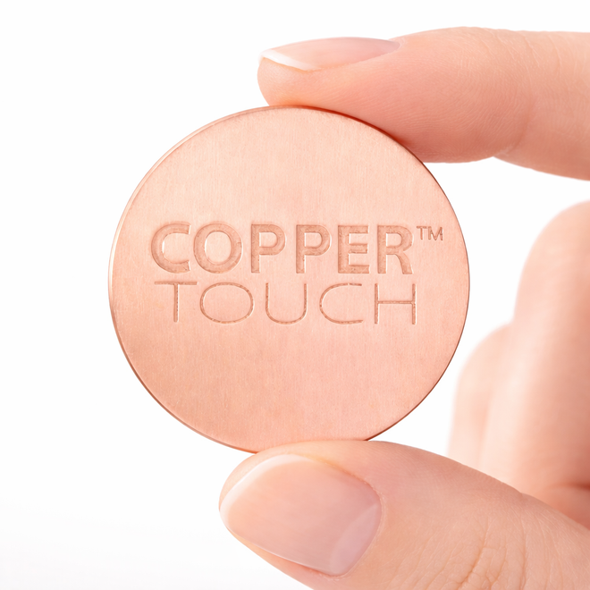 Hand holding a copper coin with the engraved text