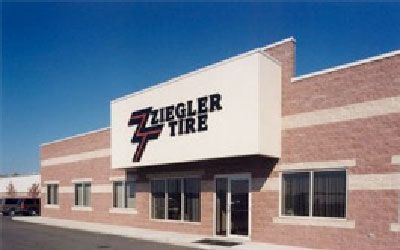 Ziegler Tire building exterior with sign above entrance and a dark vehicle to the left.