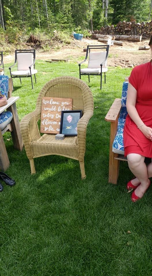A group of people are sitting in chairs on the grass.