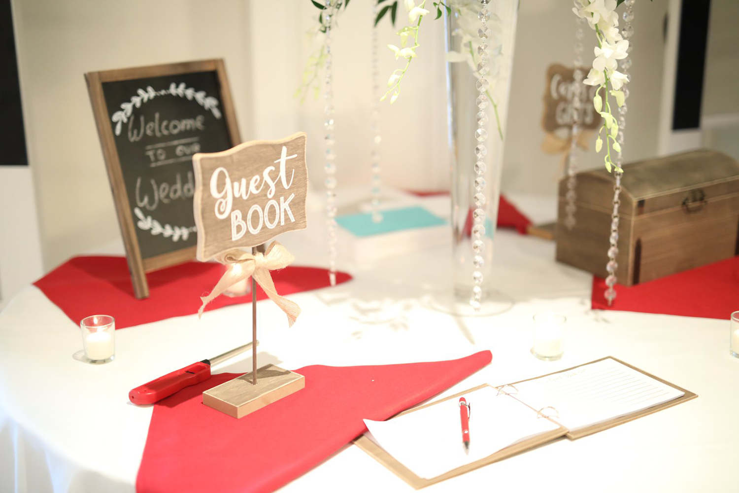 A table with a guest book and a sign on it.
