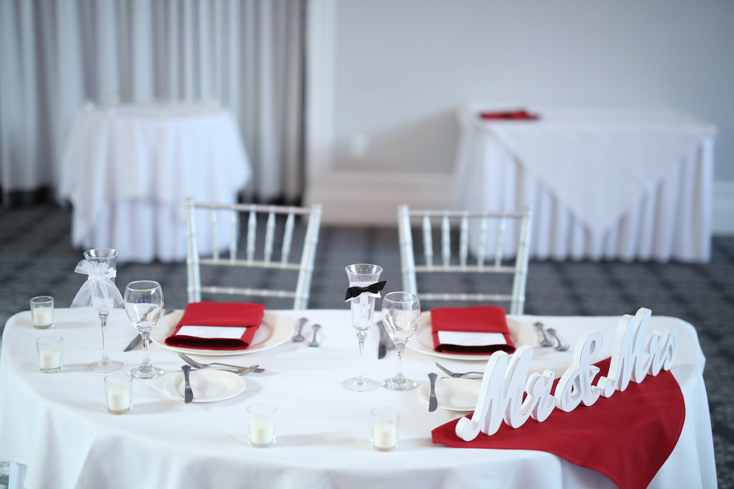 A bride and groom 's table is set for a wedding reception.