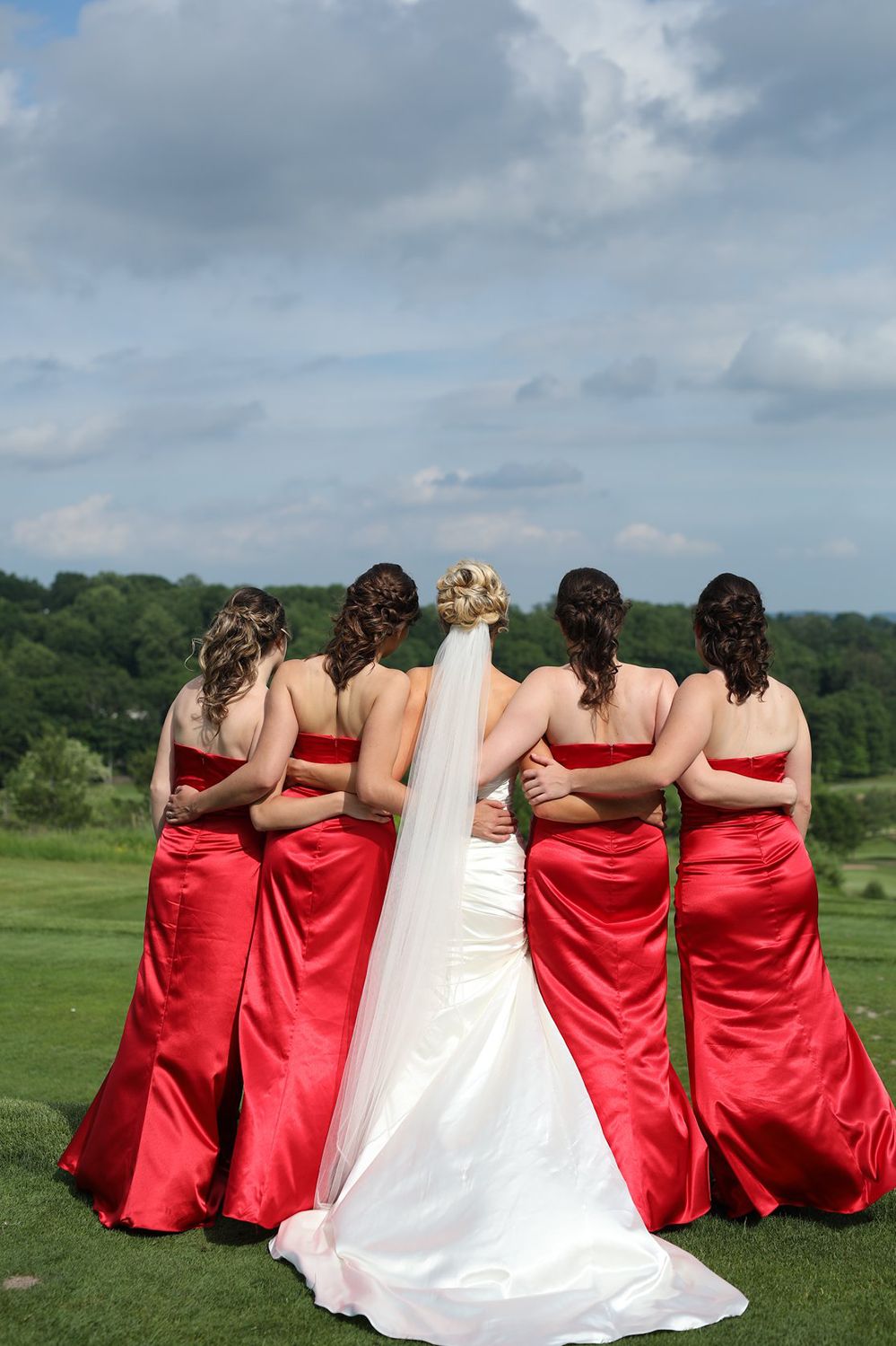 A bride and her bridesmaids are posing for a picture.