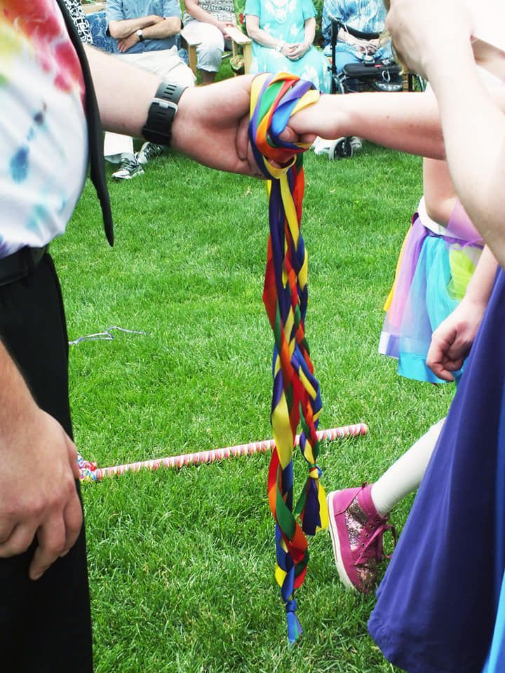 A group of people holding a colorful ribbon in their hands
