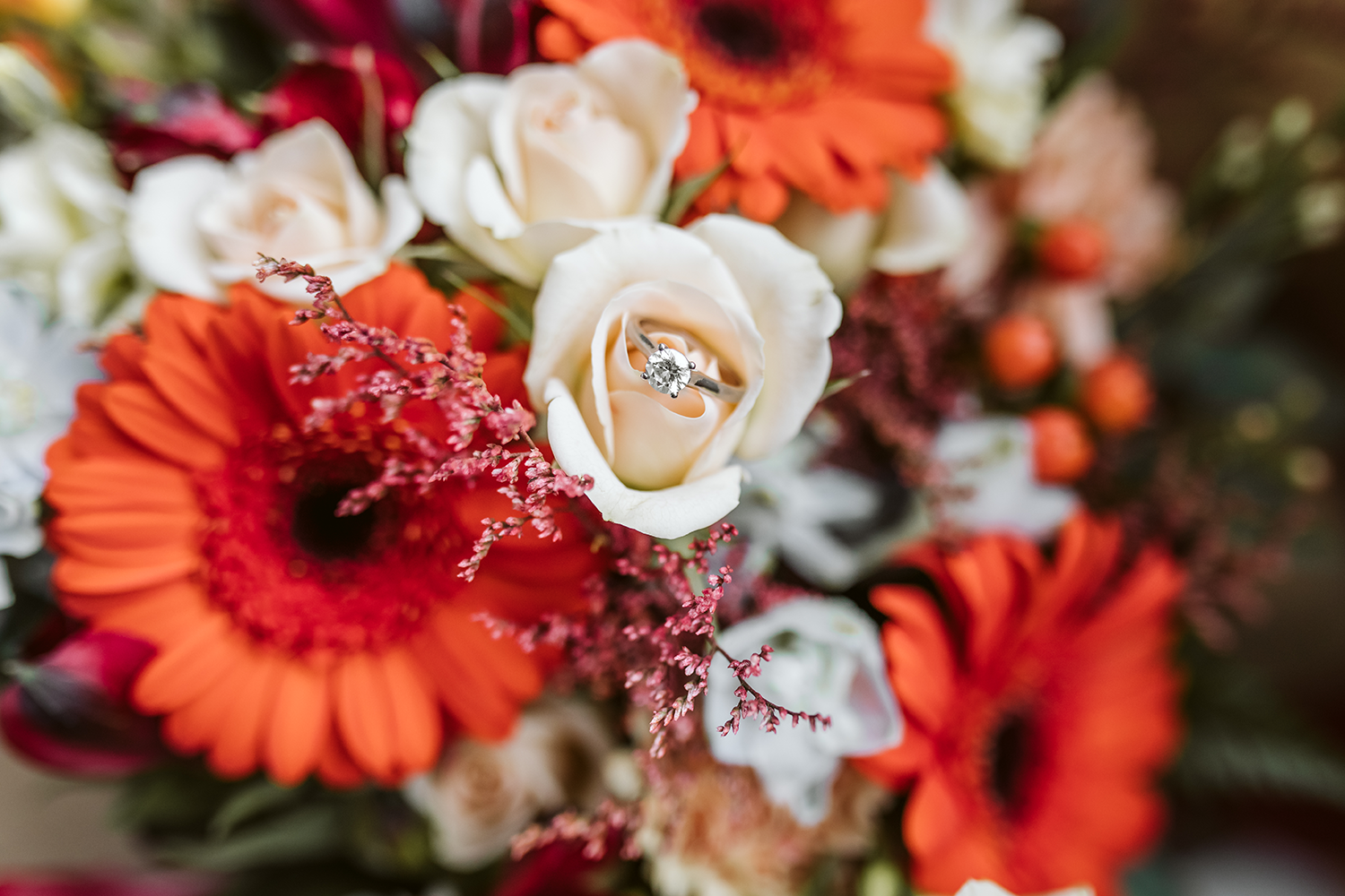 A wedding ring is sitting on top of a bouquet of flowers.