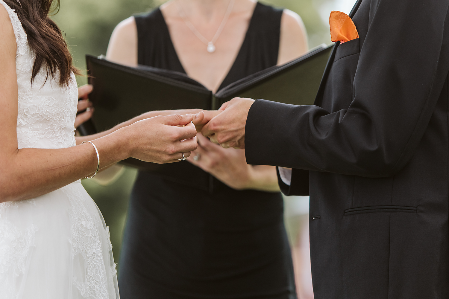 A bride and groom are holding hands during a wedding ceremony.