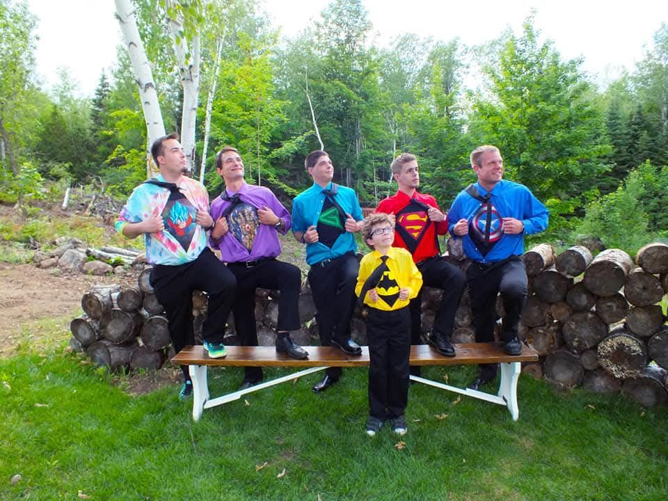 A group of men are sitting on a bench wearing ties.
