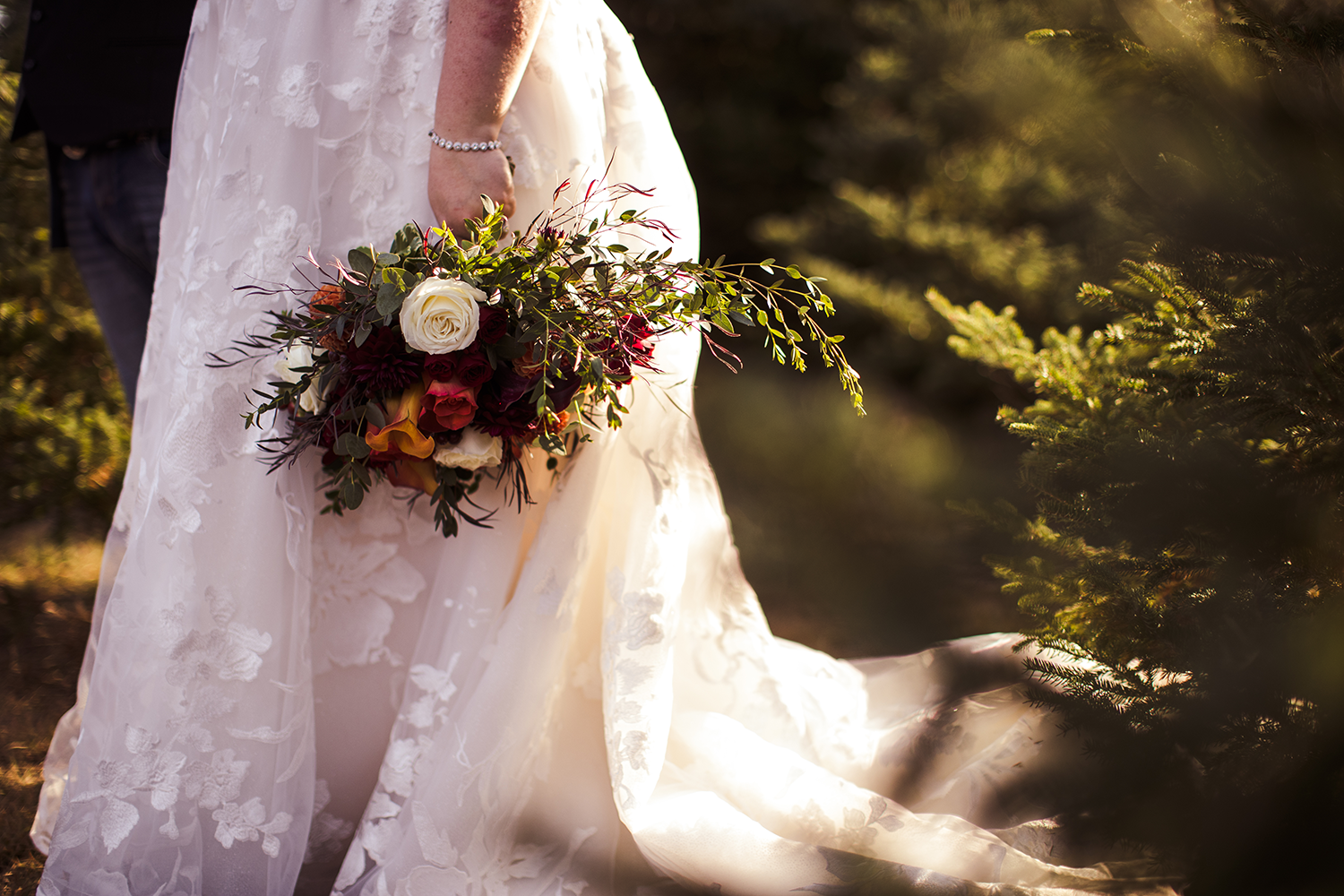 A bride in a wedding dress is holding a bouquet of flowers.