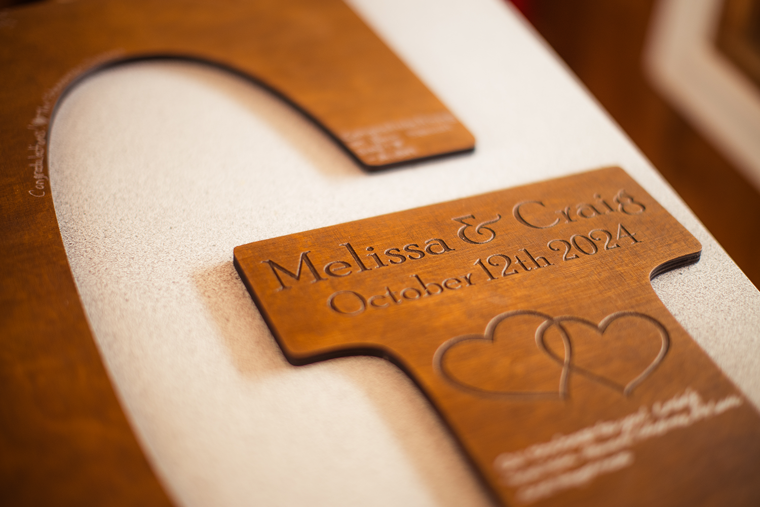 A wooden cross with the names melissa and chris engraved on it