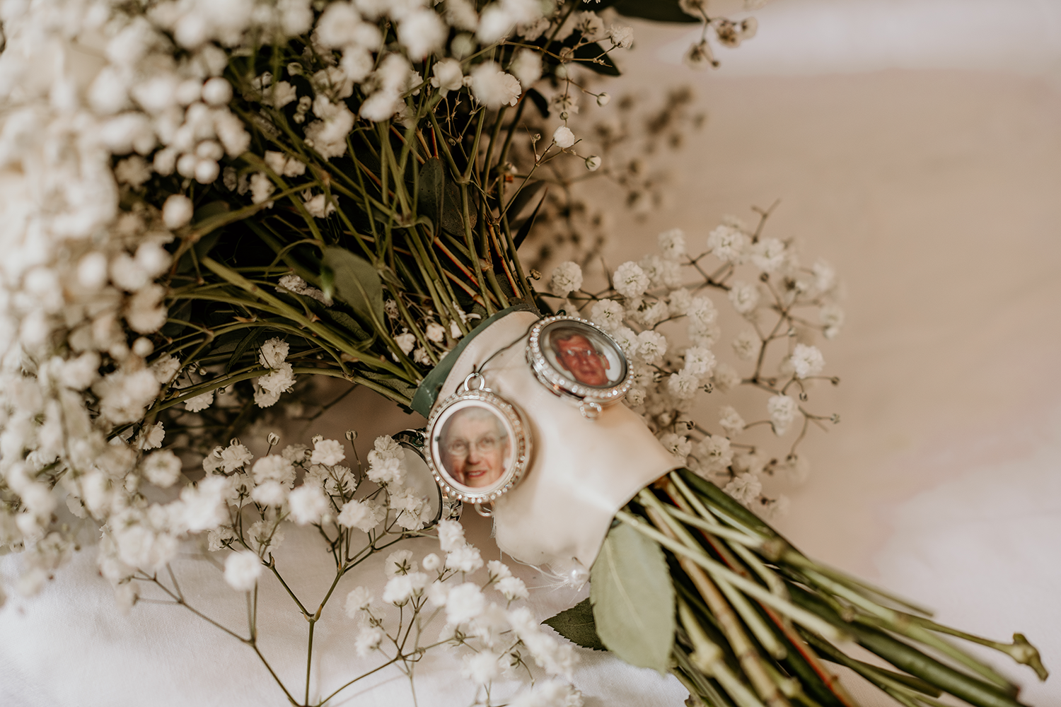 A close up of a bouquet of flowers with two pendants on it.