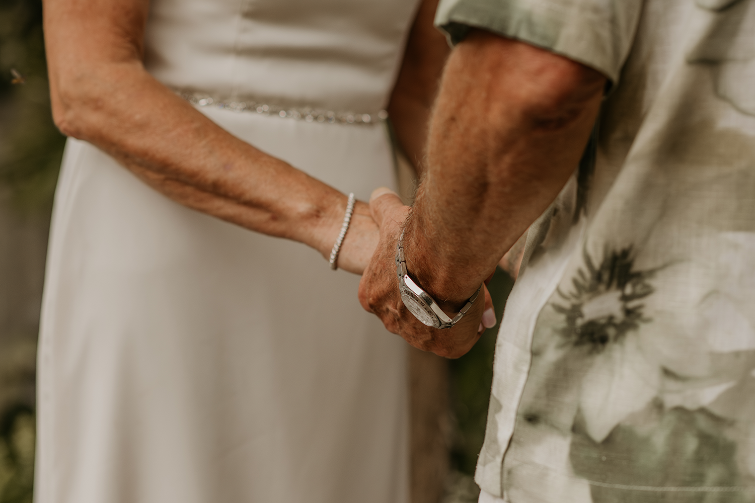 A bride and groom are holding hands during their wedding ceremony.