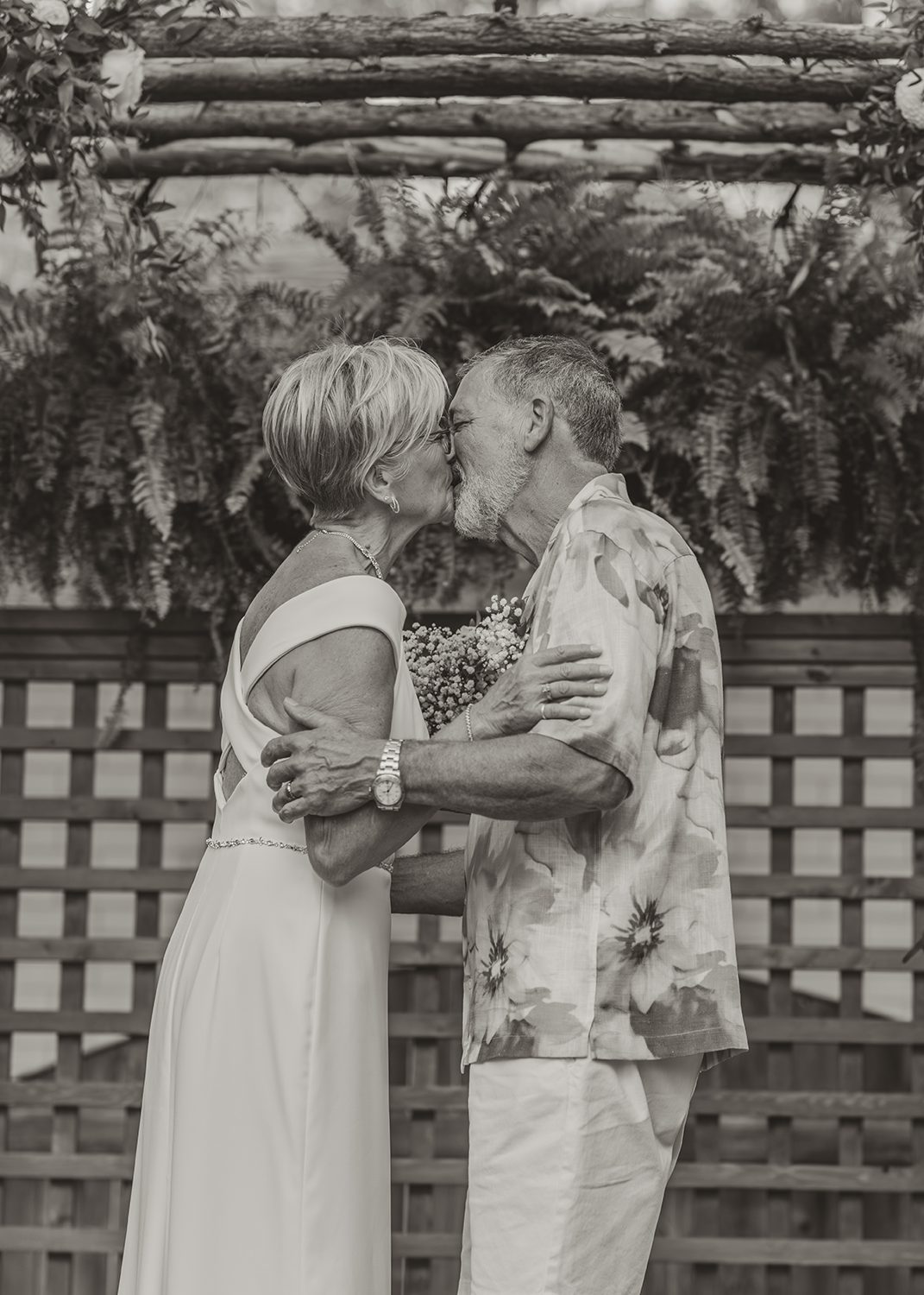 A black and white photo of a man and woman kissing.